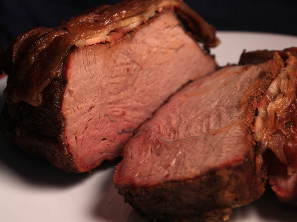 Sliced Beef Cross Rib Roast, Cooked To Medium Rare, Topped With Bacon, On Serving Platter, Smoked Bacon Covered Beef Chuck Cross Rib Roast, Sliced And On Serving Platter
