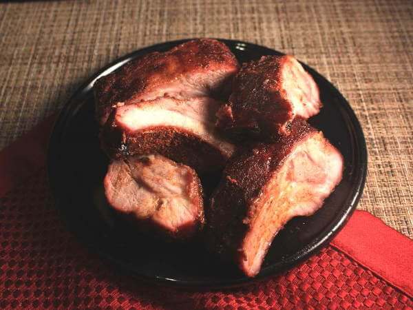 Smoked Pork Ribs On a Black Serving Dish, Resting On a Red Placemat Perfectly Smoked Pork Ribs On Platter