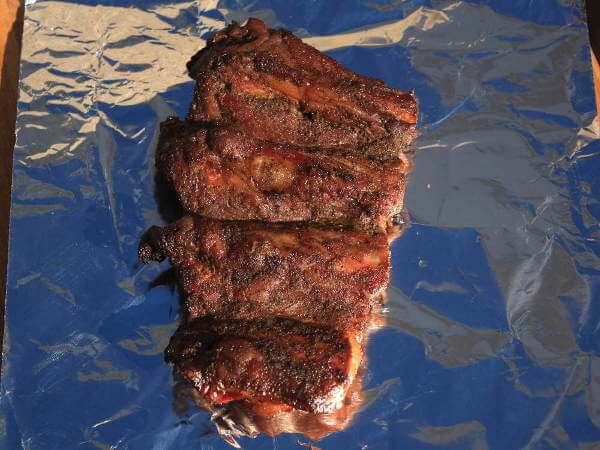 Getting Ready To Wrap Beef Ribs In Foil, Which Speeds Up Cooking and Locks In The Juice Partially Smoked Beef Ribs, About To Be Wrapped In Foil For The Final Cooking Stage