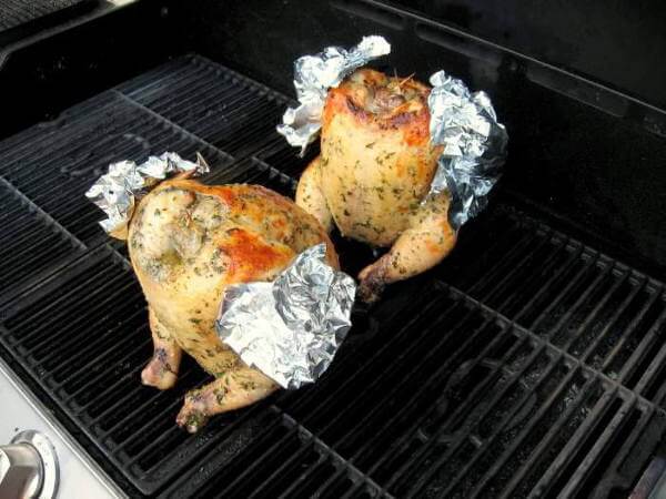 Pair of Whole Chickens Being Grill-Smoked Using The Beer Can Chicken Method