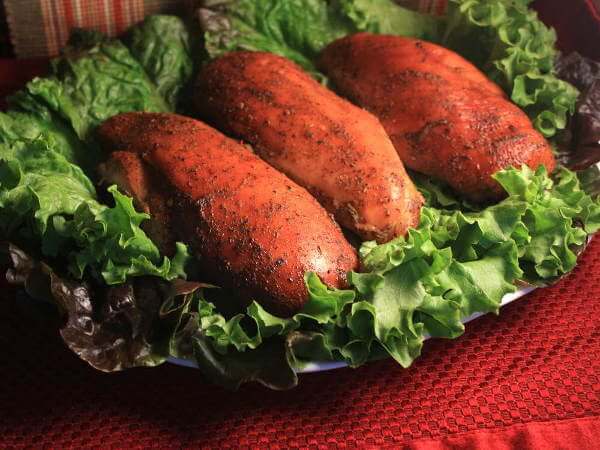 Three Smoked Chicken Breasts on Bed of Green Leaf Lettuce