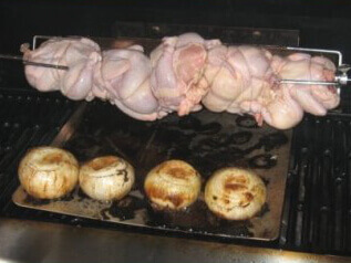Cornish Game Hens On a Rotisserie, Positioned So Juices Drip On Grilling Whole Onions Beneath Cornish Game Hens Can Be Cooked On The Rotisserie, Too