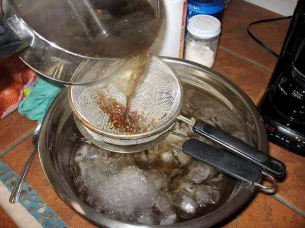 Pouring a Spice and Herb Tea Through Strainers