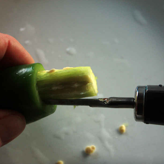 First step is to remove the jalapeno tops and core them. I've found that a simple vegetable peeler is the perfect tool! Removing a jalapeno seed core, using a household vegetable peeler. The curved blade is the perfect tool for cutting out and removing the pithy cores.