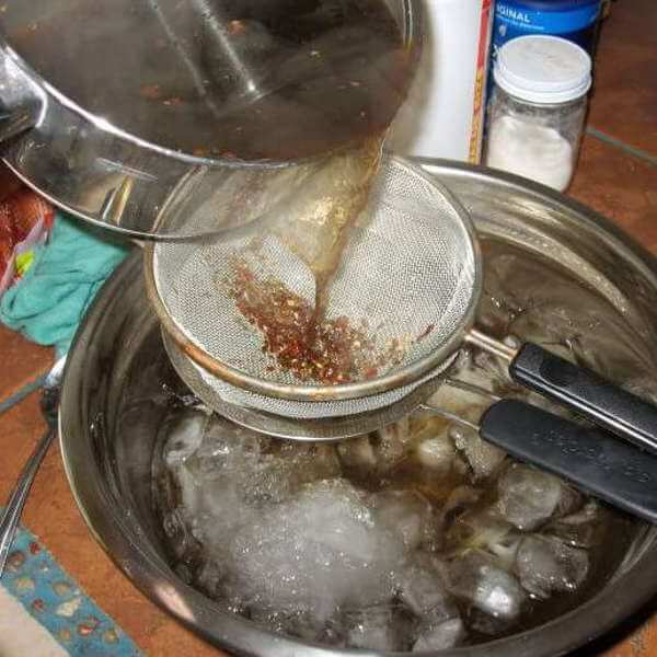 Making a Batch Of Smoked Chicken Brine. Water From Simmering Spices Is Being Strained Into Ice Bath For Quick Cooling.