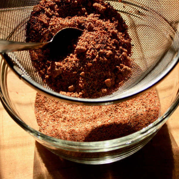 Using a Tablespoon to Force The Dry Rub Through a Coarse Sieve.