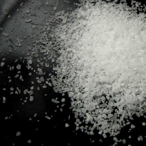 Kosher Salt On a Black Platter. Note The Irregular Shape of The Grains.