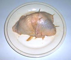 Raw Pheasant Breast, Wrapped In Chicken Skin, On Banded Dish Raw Pheasant Breast Topped With Chicken Skin