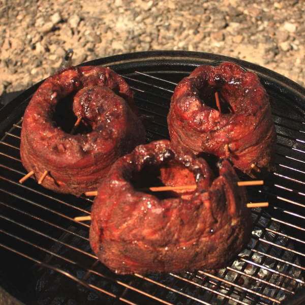 Raw, Rolled Babyback Ribs On Smoker Grate