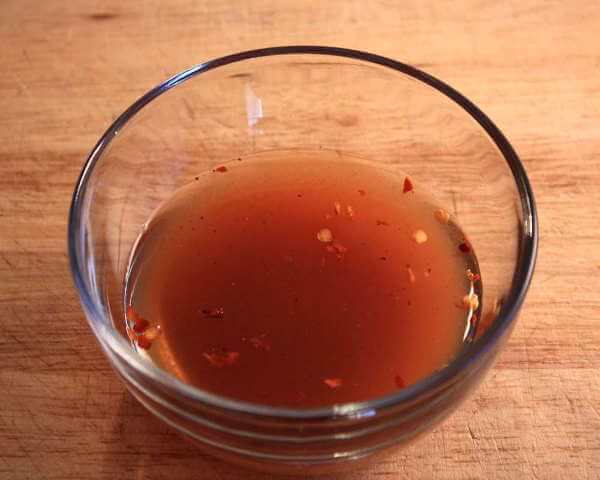 This Glass Bowl Contains Spicy Vinegar Sauce, To Be Used To Baste a Pork Shoulder A Spicy Mix of Cider Vinegar, Spices and Hot Pepper Flakes