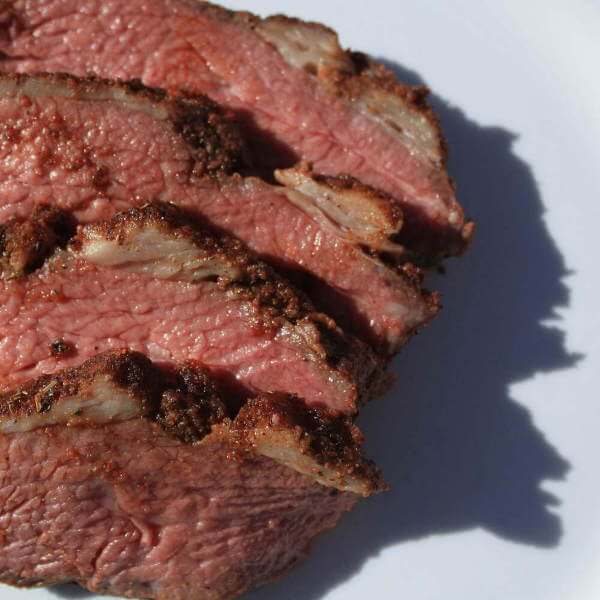 A Traditional Santa Maria Tri Tip, Smoked With Oak, Slices On a White Platter