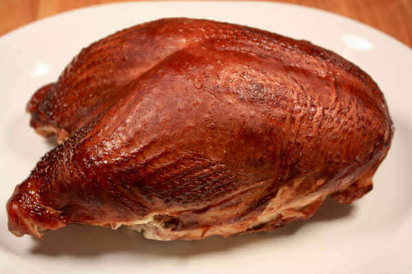 Beautifully Browned Charcoal Grilled Turkey Breast On a White Serving Platter