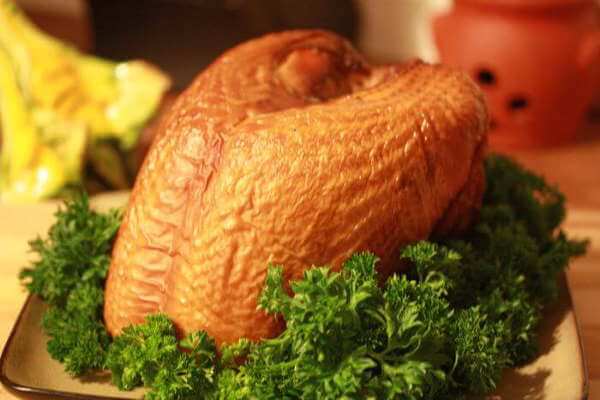 Beautifully Smoked Turkey Breast Resting In a Bed Of Leafy Green Lettuce