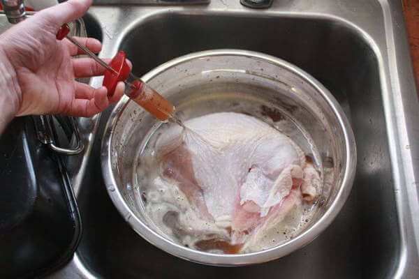 Injecting apple juice into a turkey breast