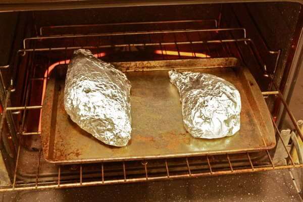 In folie verpakte pakjes eerder gerookte kalkoen gaan de oven in om opnieuw te worden verwarmd
